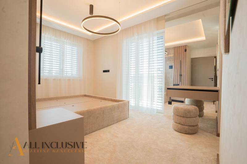 Bedroom in a family house with a bed, tables, and curtains, floor with wooden decor.