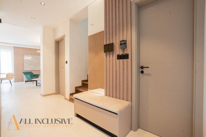 The interior of a family house with wooden decor, a staircase, and modern furniture.