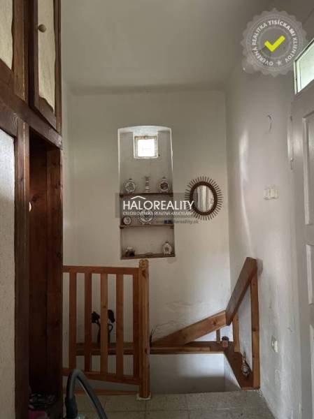A staircase in a family house with wall decorations and wooden railing.