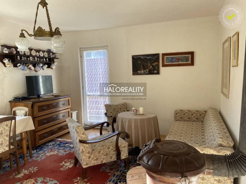 Living room in a family house with retro furniture, a sofa, and a tiled stove.