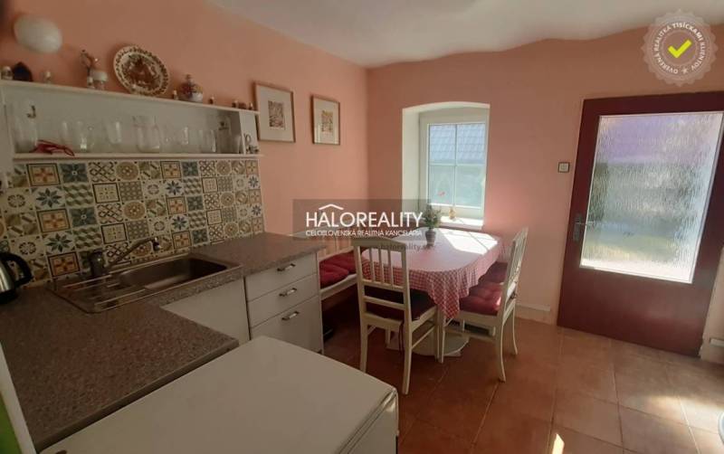 A kitchen in a family house with colorful tiles and a dining area with a view.