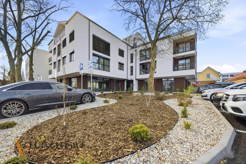 Building on Bačákova Street in Dunajská Streda with a parking lot and a landscaped garden.