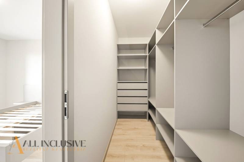 A wardrobe in a 2-room apartment with shelves and a floor with a wooden decor.