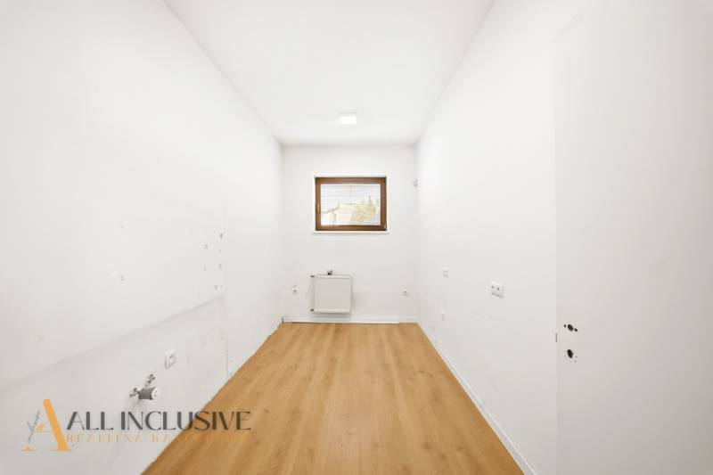 Commercial spaces with white walls and wood-patterned flooring.