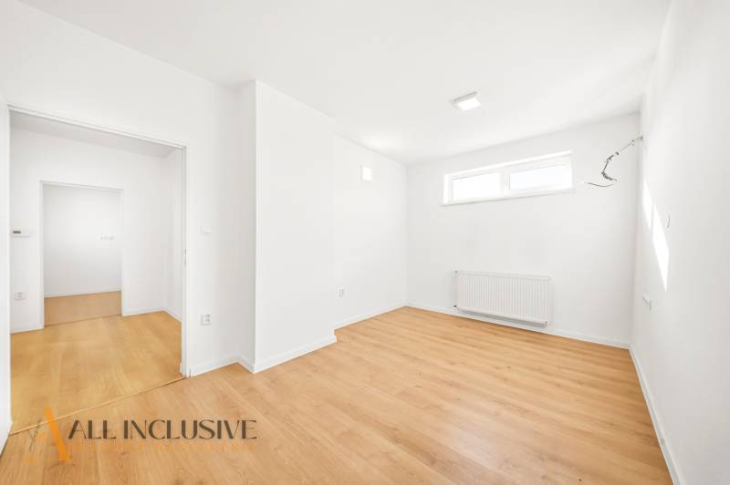 Commercial spaces with white walls and wood-patterned flooring.