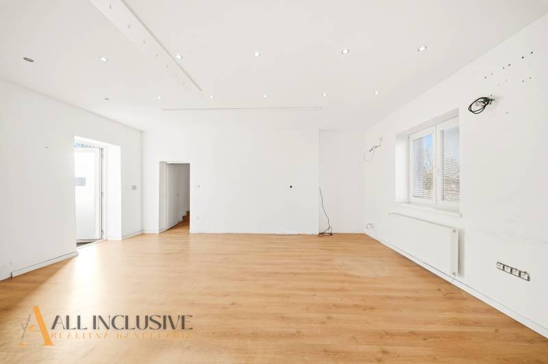 Spacious commercial spaces with white walls and a floor with a wooden decor.