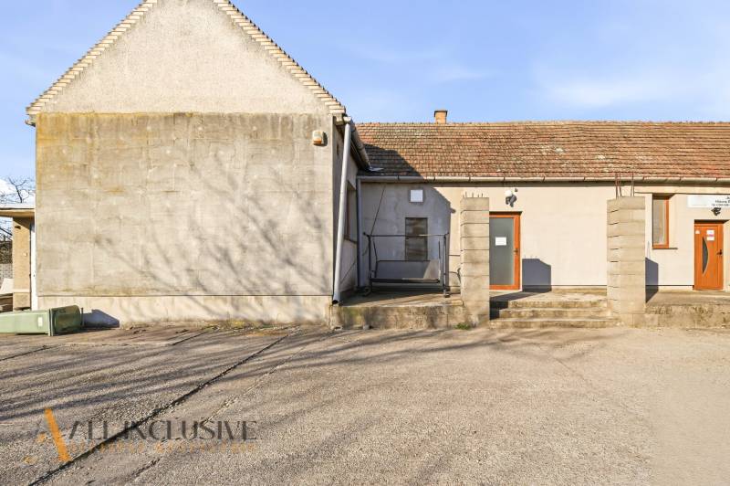 Commercial premises in Jelka with a simple facade and a concrete sidewalk.