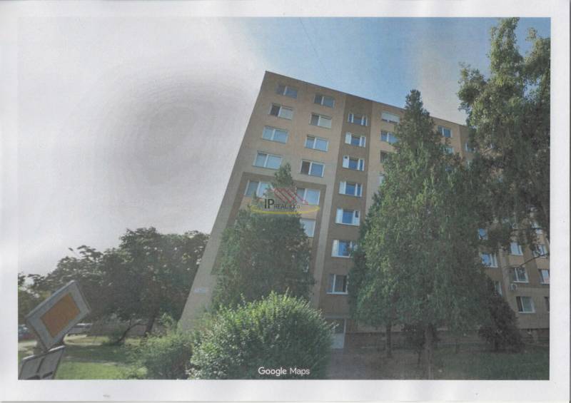 Apartment building with many windows and trees in front of it on T.G. Masaryk Street in Nové Zámky.