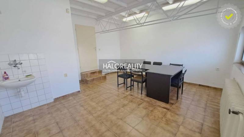 Offices with a dining table and tiles, a sink in the corner of the room.