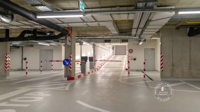 Underground garage with a ramp, lighting, and technical installations.