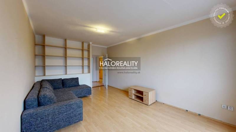 Living room with a sofa and built-in shelves in a 2-room apartment.