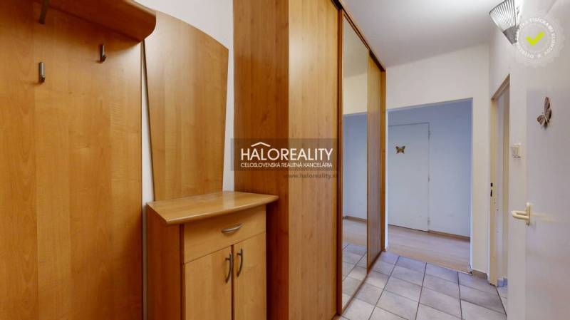 A hallway in a 2-room apartment with a built-in wardrobe and a floor with a wooden decor.