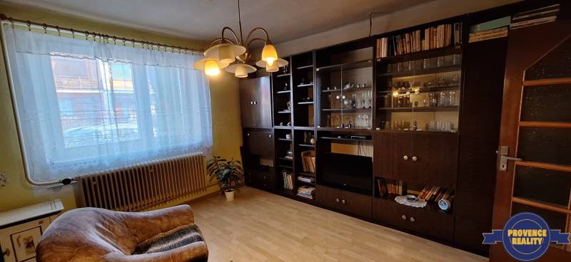 Living room in a family house with a library and wooden decor flooring.