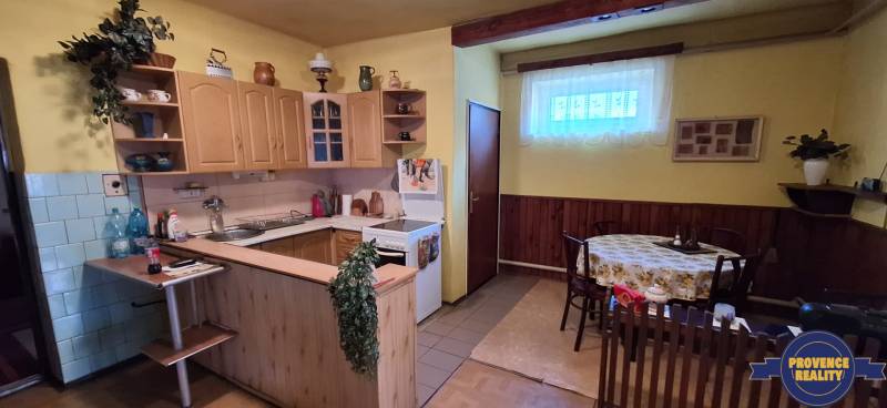 A kitchen in a family house with wooden cabinets and a dining table.