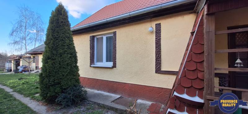 A family house in the village of Holiare with a red roof and a well-maintained garden.