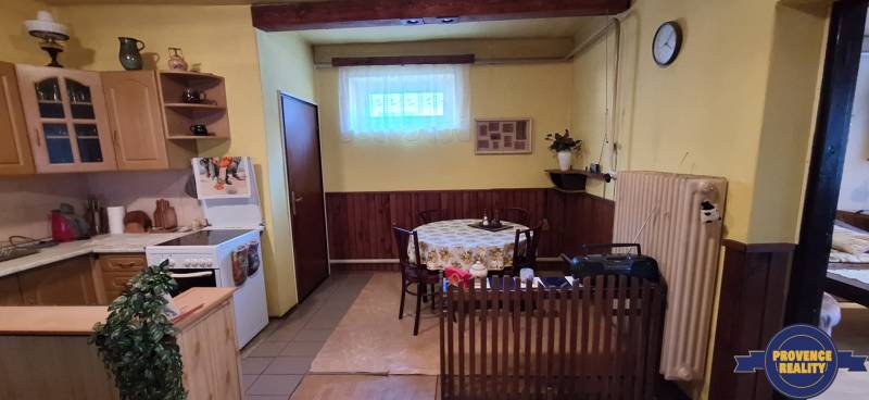 Kitchen and dining area in a family house with wooden elements and a curtain.