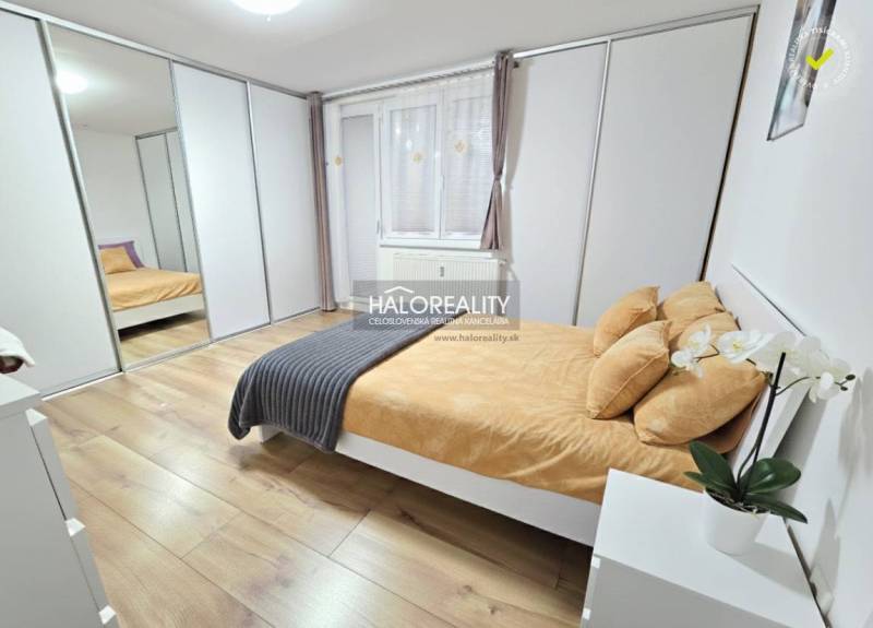 A bright bedroom in a three-room apartment with a large built-in wardrobe and a floor with a wooden decor.