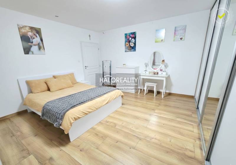 A bedroom with a bed, a wardrobe, and a wooden decor floor in a 3-room apartment.
