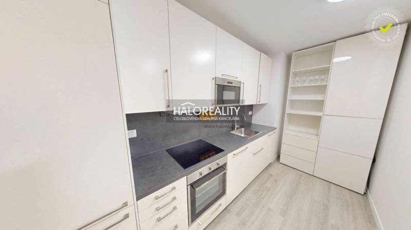 Interior of a 2-room apartment with a wooden decor floor, kitchen, and living room.