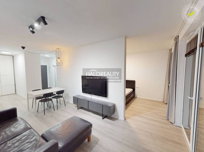 Hallway of a 2-room apartment with a wooden decor floor, bathroom, and dining table.