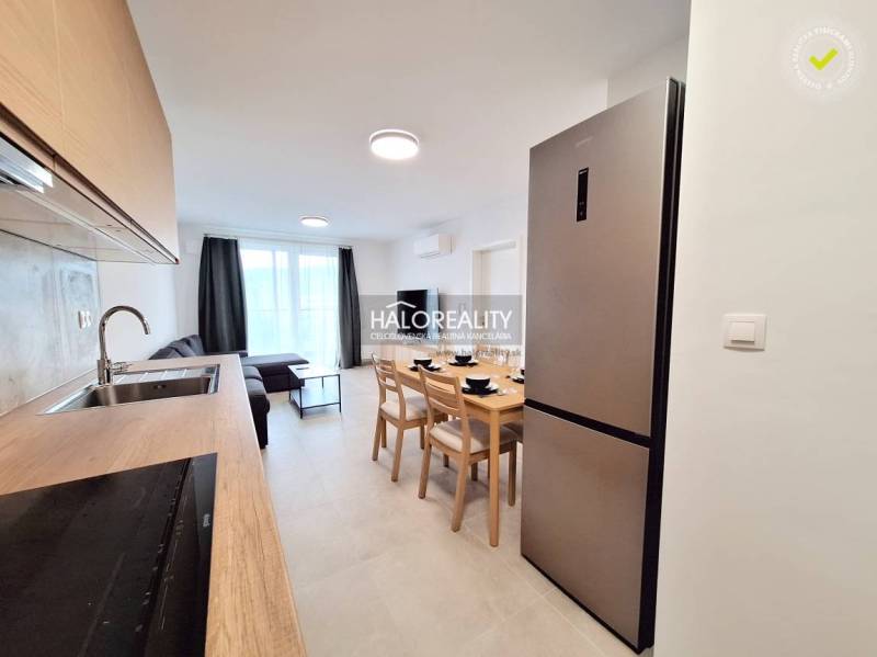 A spacious kitchen with a dining table and a sofa in a 2-room apartment.