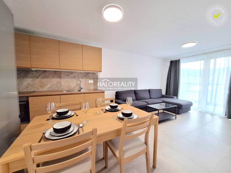 A kitchen in a 2-room apartment with wooden decorative cabinets and a set table.