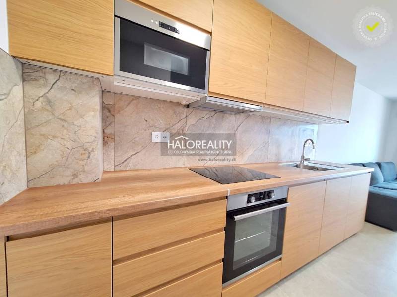 A kitchen with a dining area in a 2-room apartment, flooring with a wooden decor.