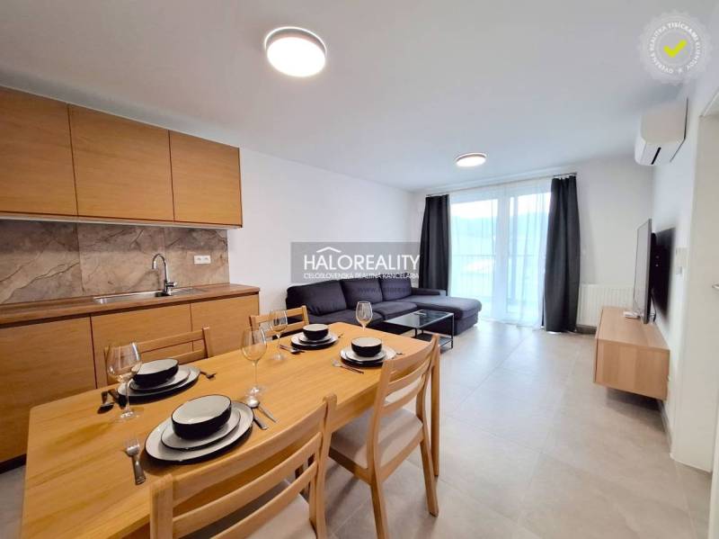 Living room in a 2-room apartment with a kitchenette, dining table, and sofa.