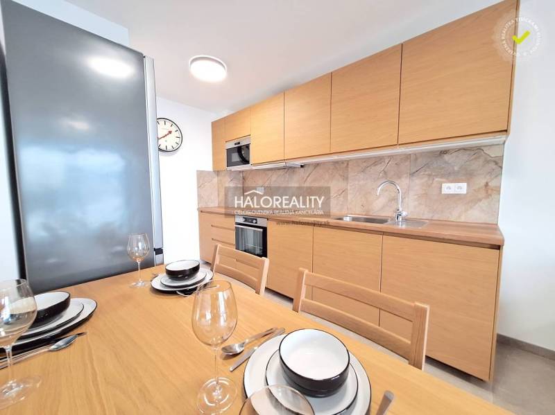 A kitchen in a 2-room apartment with wooden decor and a dining table.