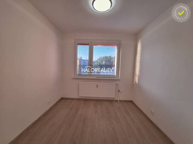 A room with white walls and a wooden decor floor in a 3-room apartment.