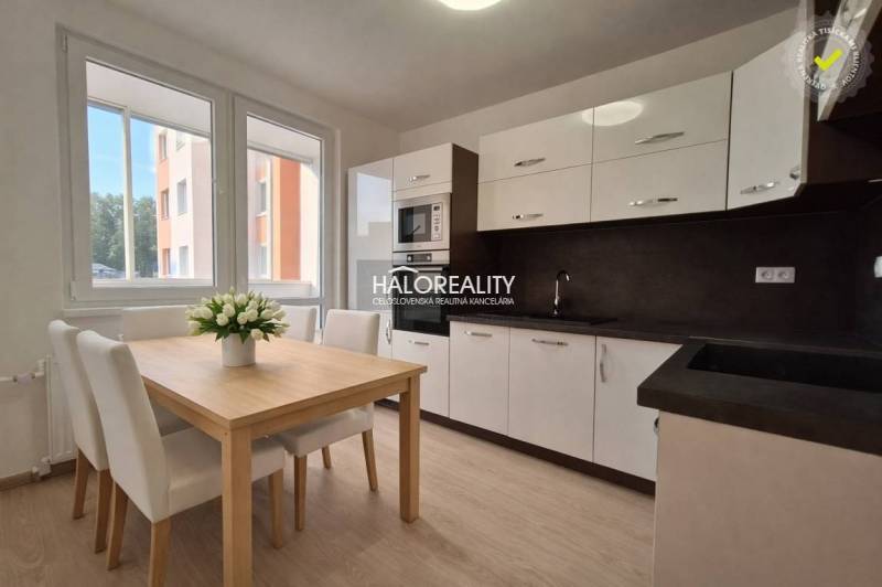 A kitchen in a 3-room apartment with a wooden decor floor and a dining table.