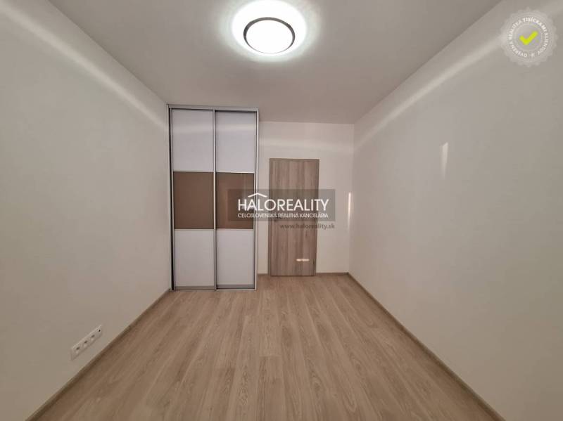 A room with a wooden decor floor and a built-in wardrobe in a 3-room apartment.