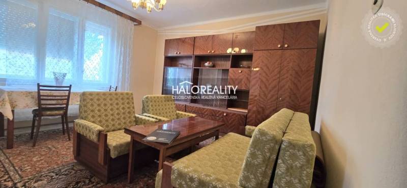 Living room in a family house with a sofa, retro television, and wooden decor.