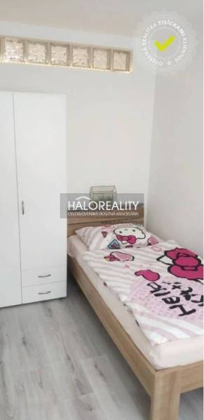 A simple room in a 3-room apartment with a wooden decor floor and a child's bed.