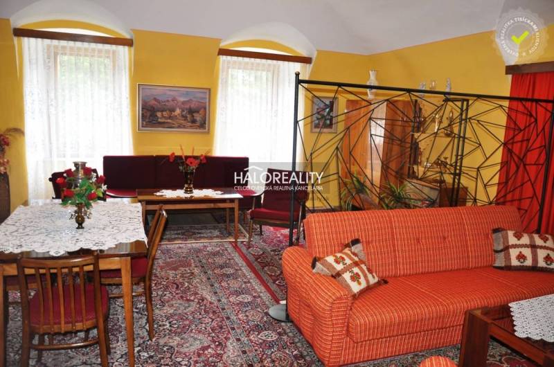 A living room in a family house with a sofa, a coffee table, and curtains, creating a cozy space.
