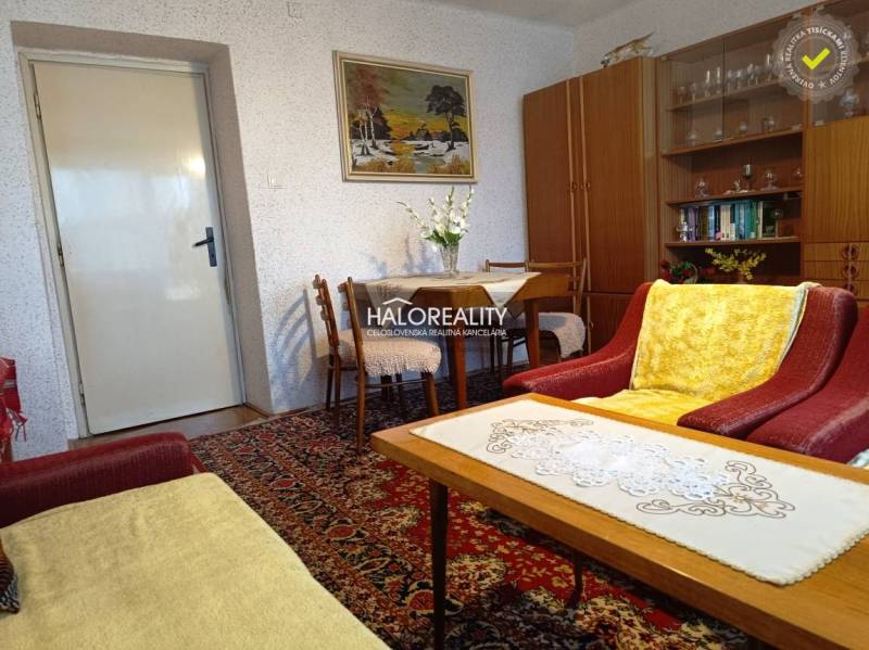 Living room with carpets and wooden decor in a 2-room apartment.
