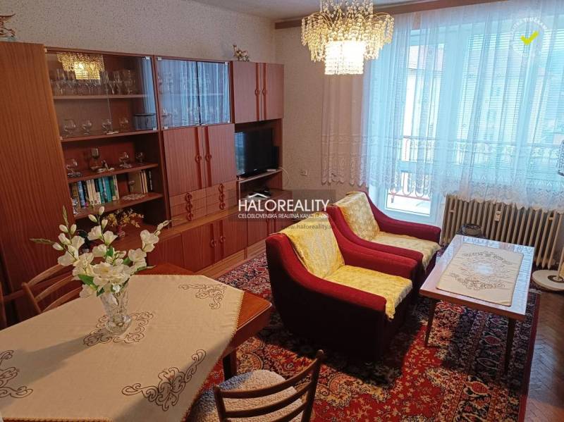 Living room with a sofa, television, and floral decorations in a 2-room apartment.