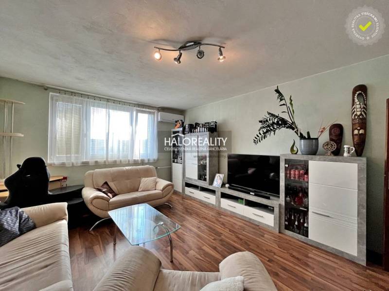 Living room with wood-patterned flooring in a 3-room apartment, with a comfortable sofa.