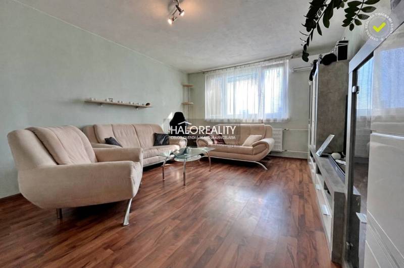 Living room in a 3-room apartment with cream sofas and a wooden-patterned floor.