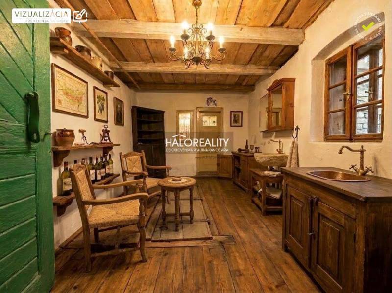 A rustic room with ceiling beams, a wooden decor floor, and historical furniture.