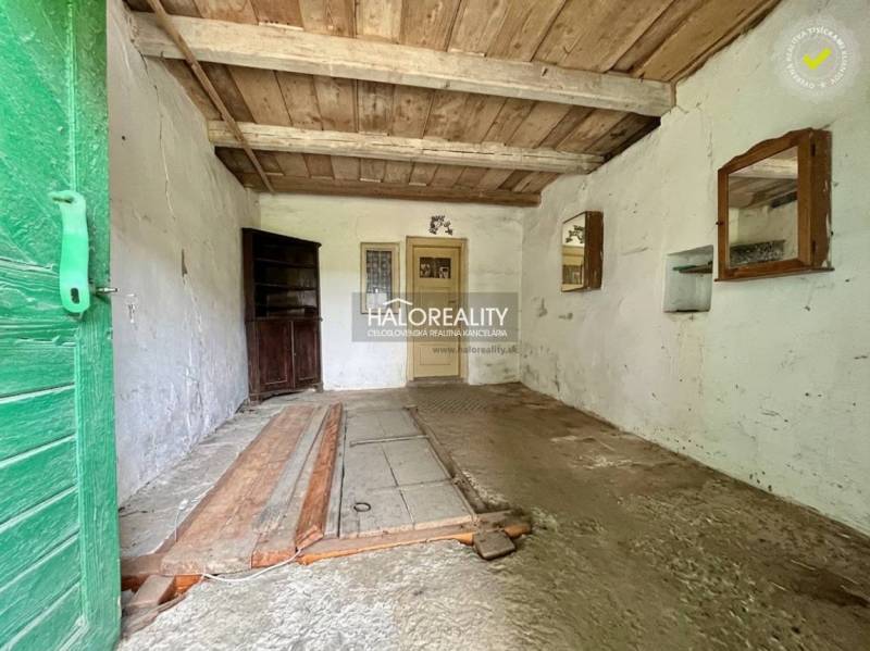 An older interior with a wooden ceiling, old flooring, and green doors in the Gardens.