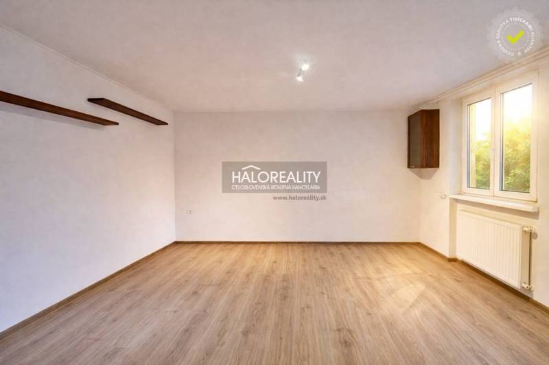 A spacious room with a light wood-patterned floor in a 4-room apartment.