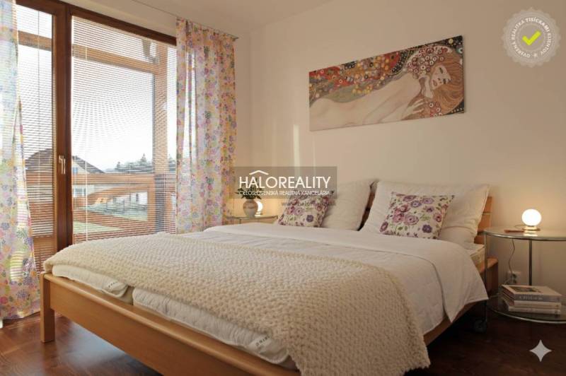 A bright bedroom in a 3-room apartment, with a bed and a wooden-patterned floor.