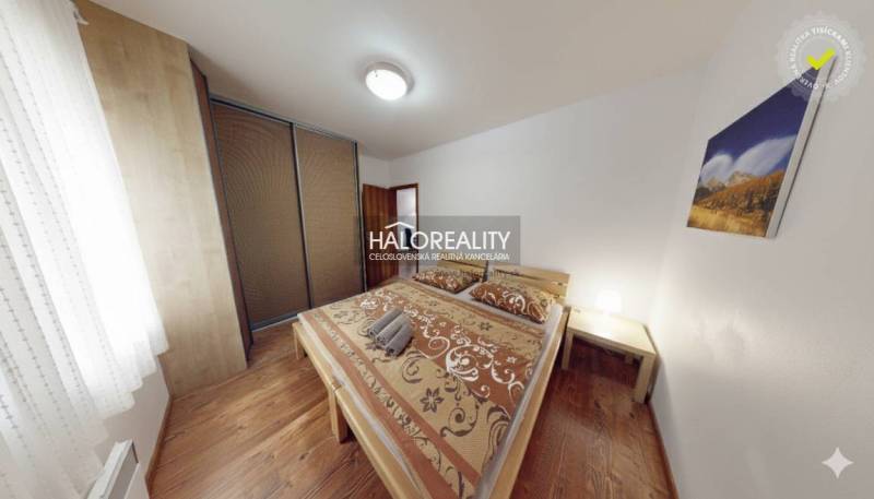 A bedroom in a 3-room apartment with wooden decor, a bed, and a wardrobe.