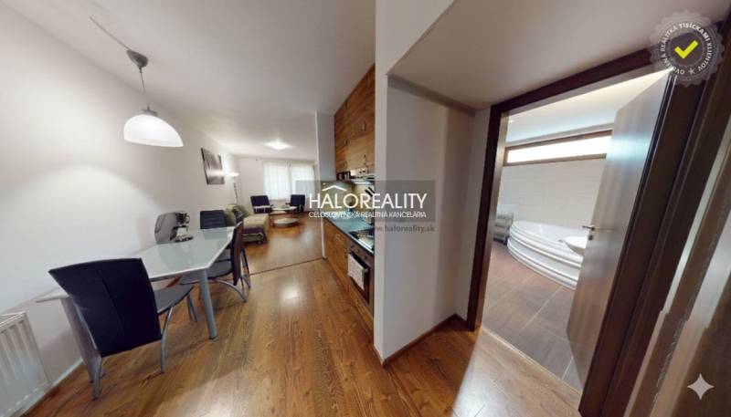 Interior of a 3-room apartment with a wooden decor floor, kitchen, and bathroom with a corner bathtub.