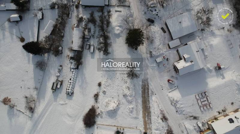 Winter landscape in Liptovské Beharovce, snow-covered plots - housing, houses, and trees from above.