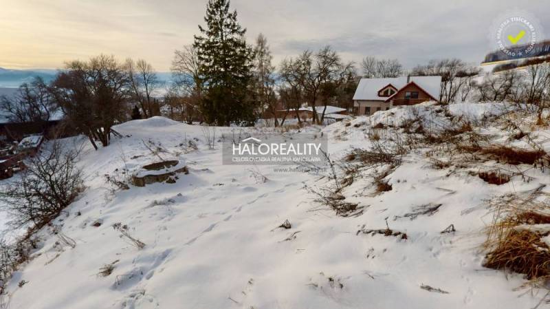 Snow-covered residential plots surrounded by nature in Liptovské Beharovce with a view of the hills.