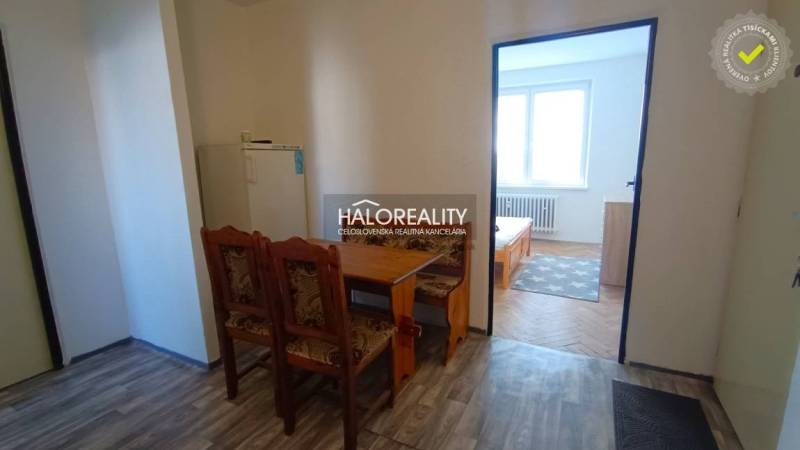 A kitchen in a 2-room apartment with a wooden decor and a dining table.