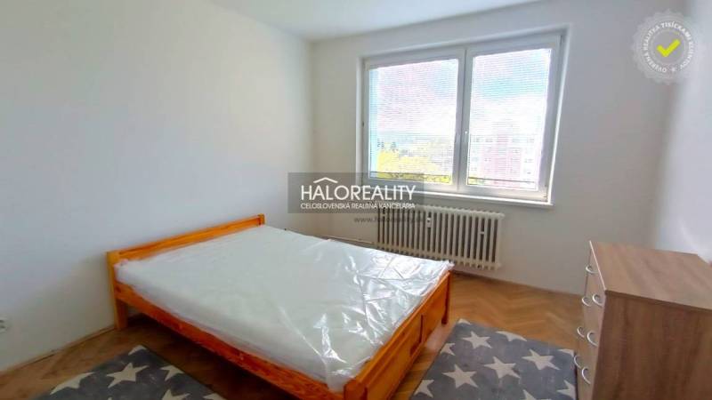 Bedroom in a 2-room apartment with a bed and a wooden decor floor.