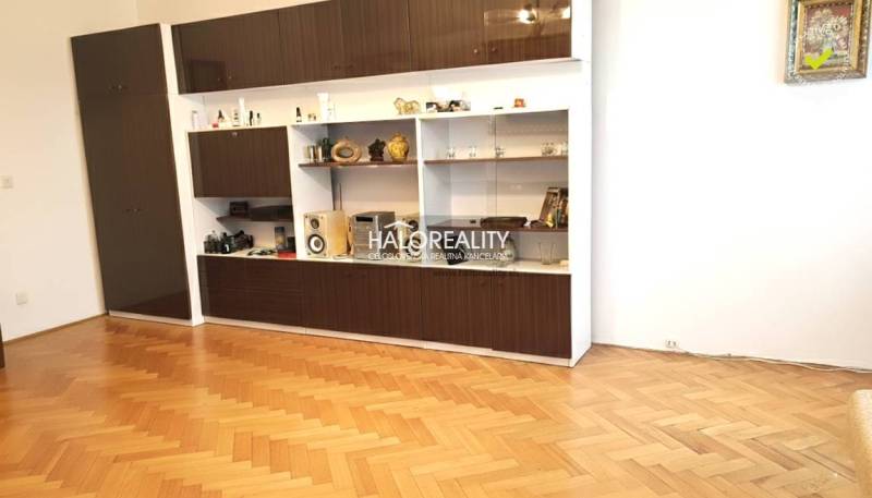 Living room wall unit with cabinets and wooden decor flooring in a 3-room apartment.